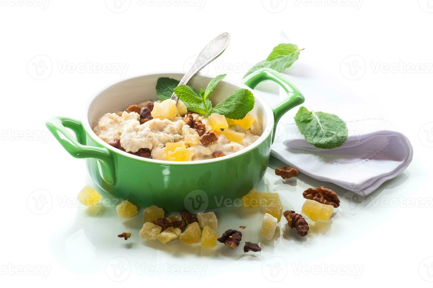 cooked boiled sweet oatmeal with nuts and candied fruits in a bowl photo