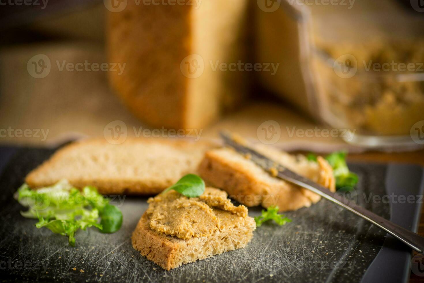 homemade meat pate with bread on a wooden table photo