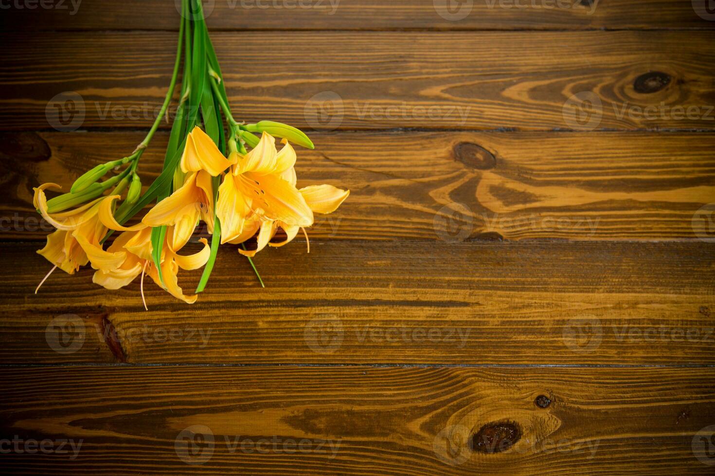 bouquet of beautiful yellow lilies on wooden table photo