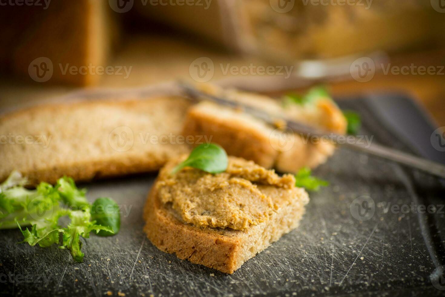 homemade meat pate with bread on a wooden table photo