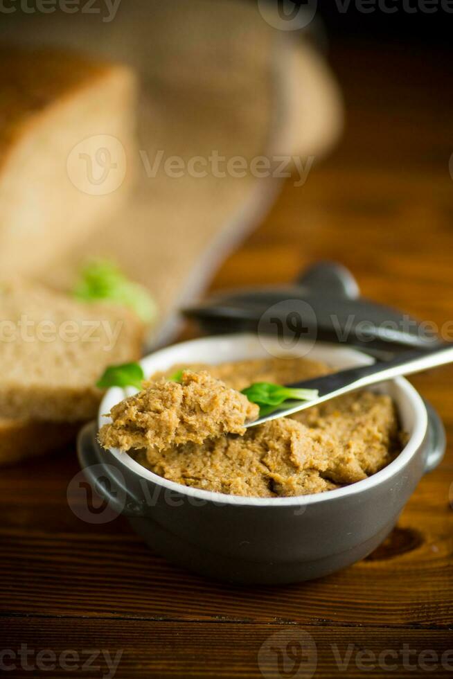 homemade meat pate in a ceramic bowl on a wooden table photo