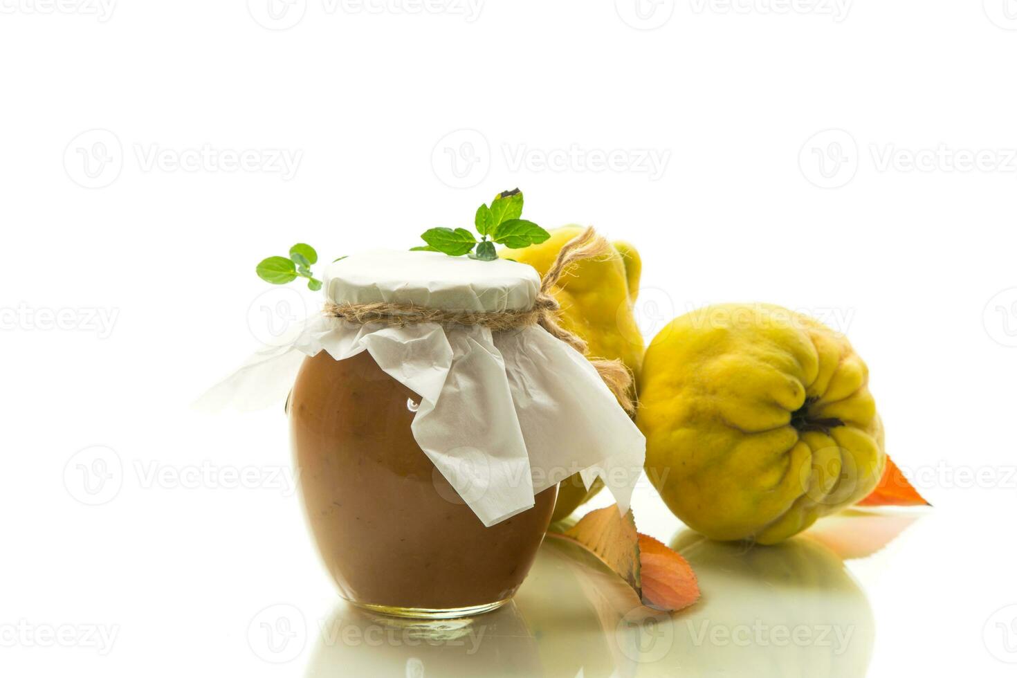 Ripe quince fruit with jam in a glass jar isolated on a white background. photo