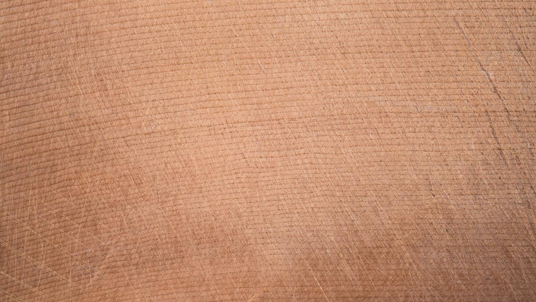 top view of brown hardwood cutting board for kitchen accessories. There are scratches from use. Natural Wood texture Background, Surface of teak, Wooden Desk Texture. photo