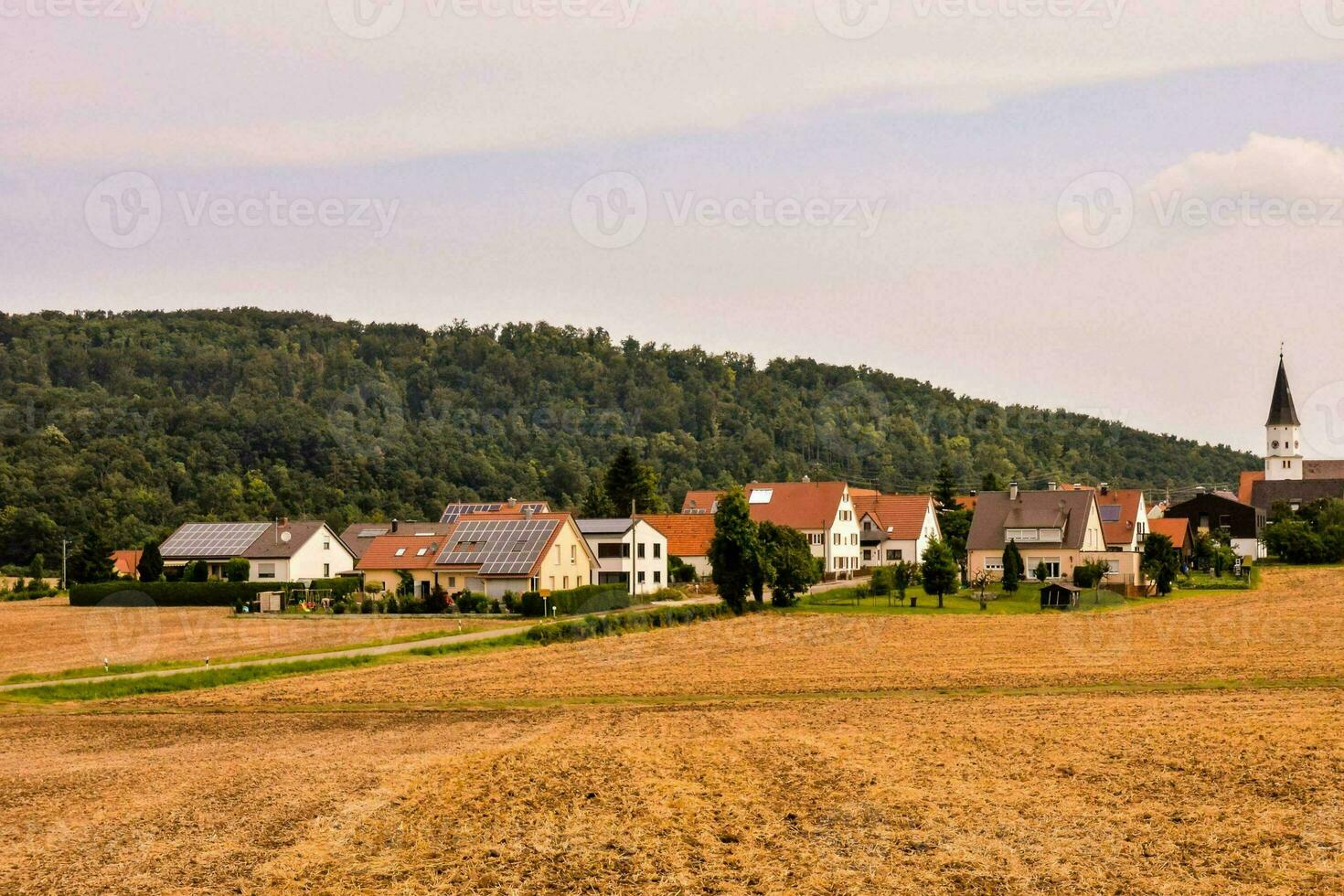 a village in the countryside with a church in the distance photo