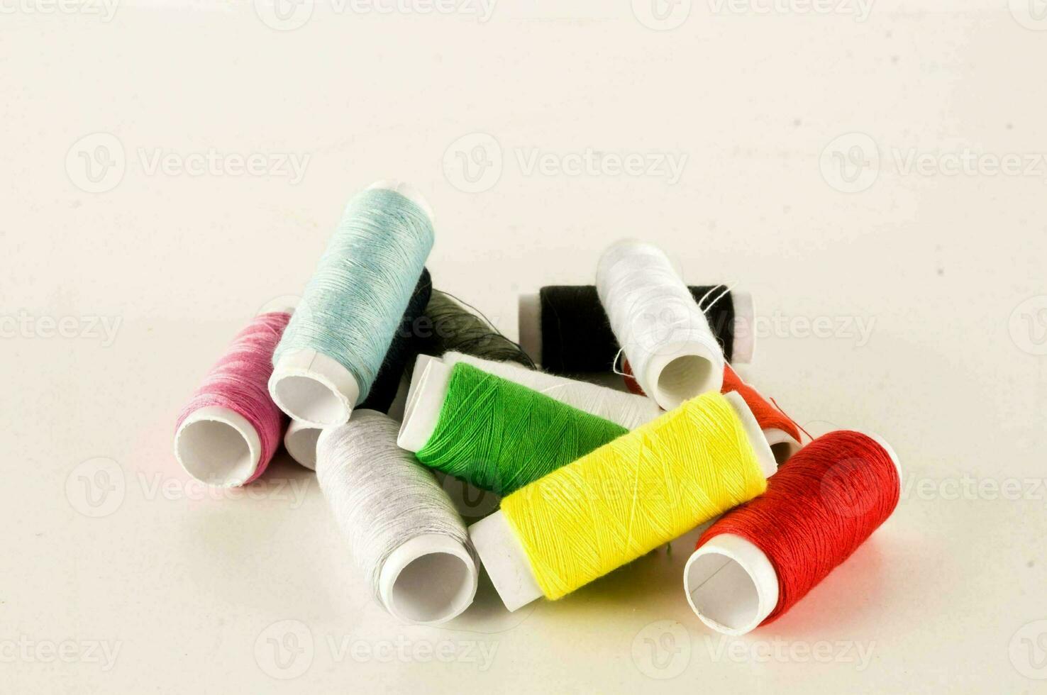 a pile of different colored thread on a white background photo