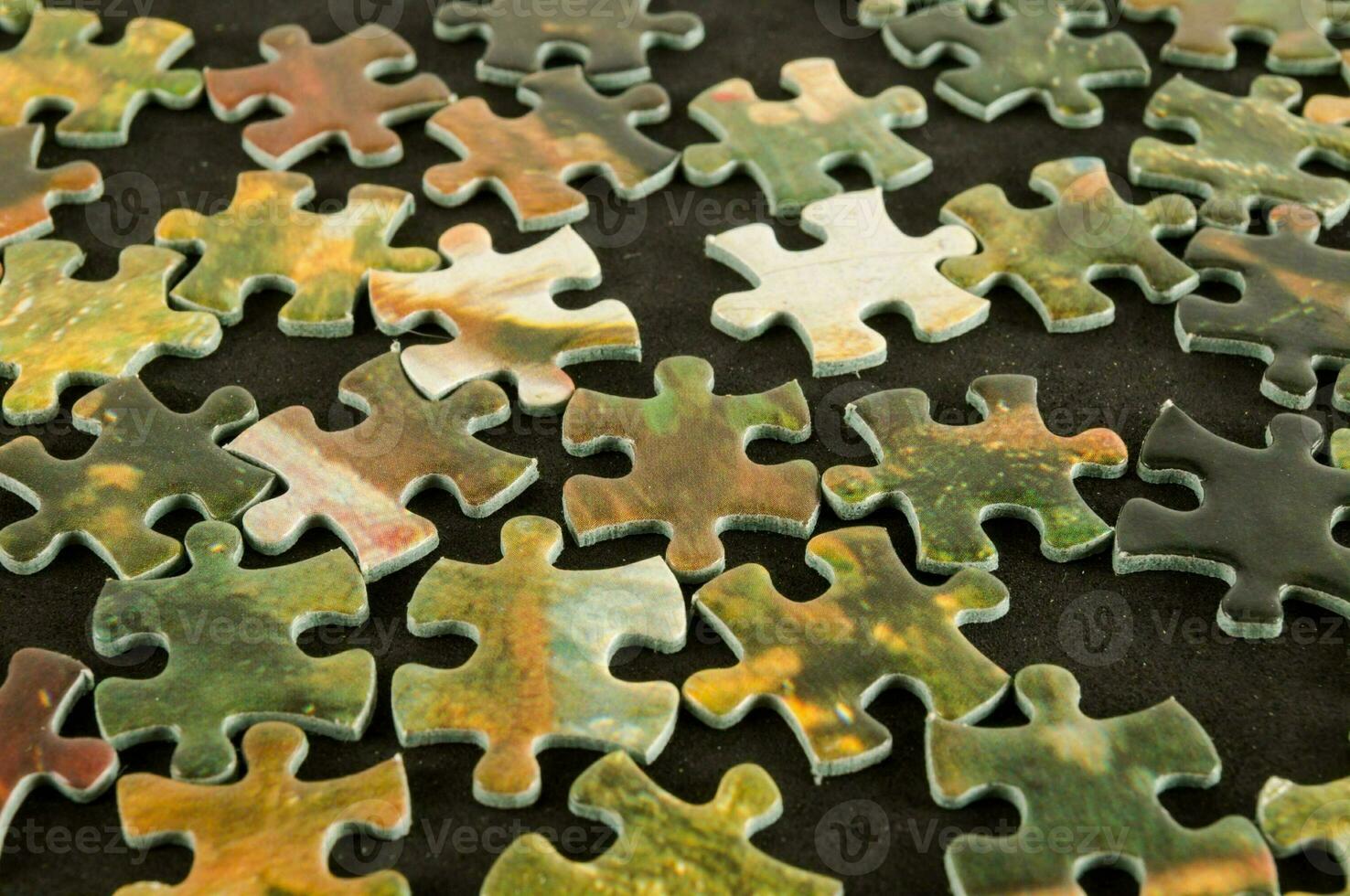 a pile of puzzle pieces on a black surface photo