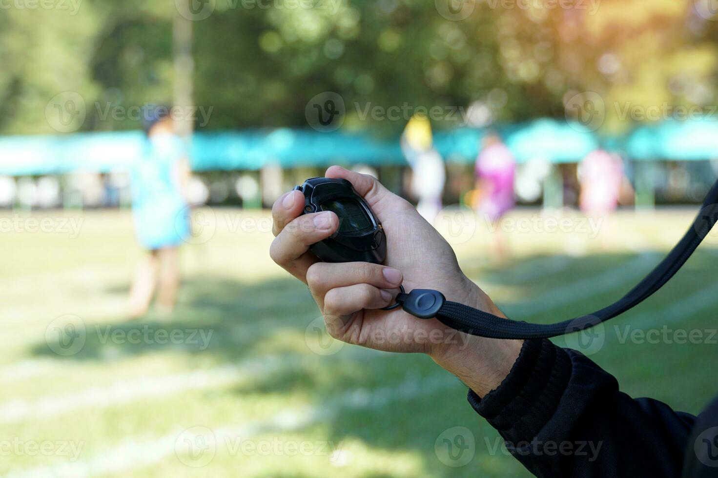 el entrenador cronometrado el terminar línea con un cronógrafo a determinar el ganador de el colegio Deportes día corriendo evento. suave y selectivo enfocar. foto