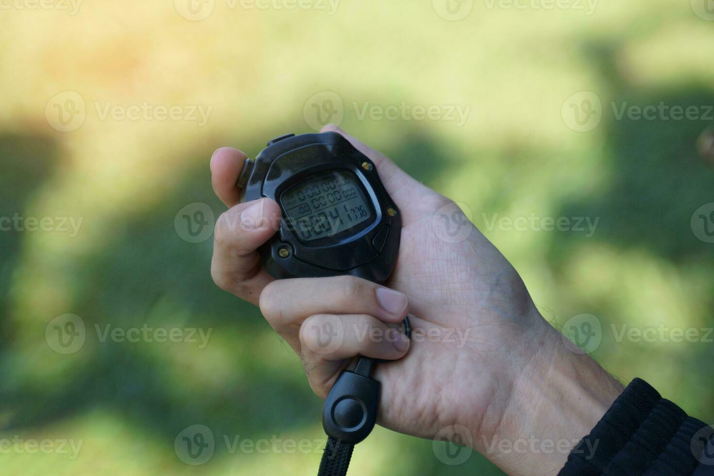 Coach holds a stopwatch to check the runners' speed statistics during practice. soft and selective focus. photo