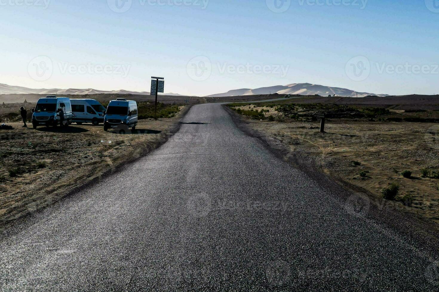 dos furgonetas estacionado en el lado de un la carretera en el Desierto foto