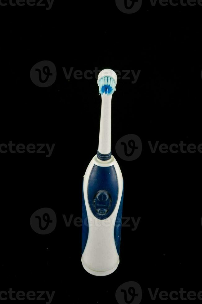 a blue and white electric toothbrush on a black background photo