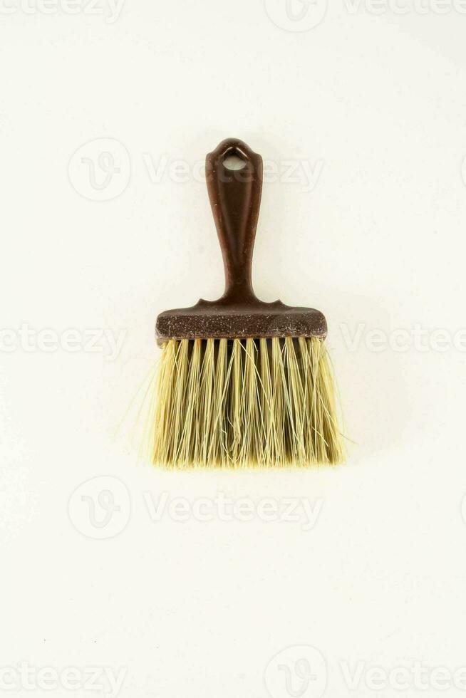 a brush with a brown handle on a white surface photo