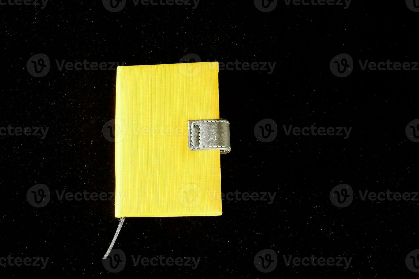 a yellow notebook with a silver clip on it photo