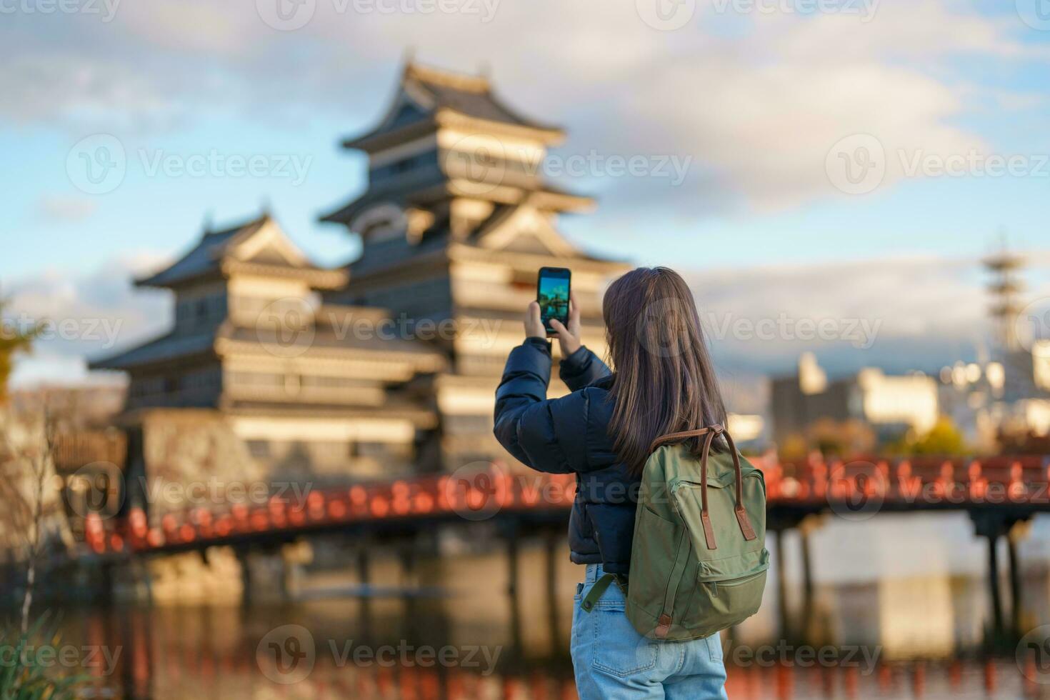 Woman tourist Visiting in Matsumoto, happy Traveler taking photo Matsumoto Castle or Crow castle. Landmark and popular for tourists attraction in Matsumoto, Nagano, Japan. Travel and Vacation concept