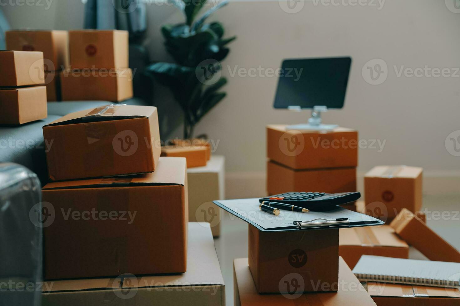 Startup SME small business entrepreneur of freelance Asian woman wearing apron using laptop and box to receive and review orders online to prepare to pack sell to customers, online sme business ideas. photo