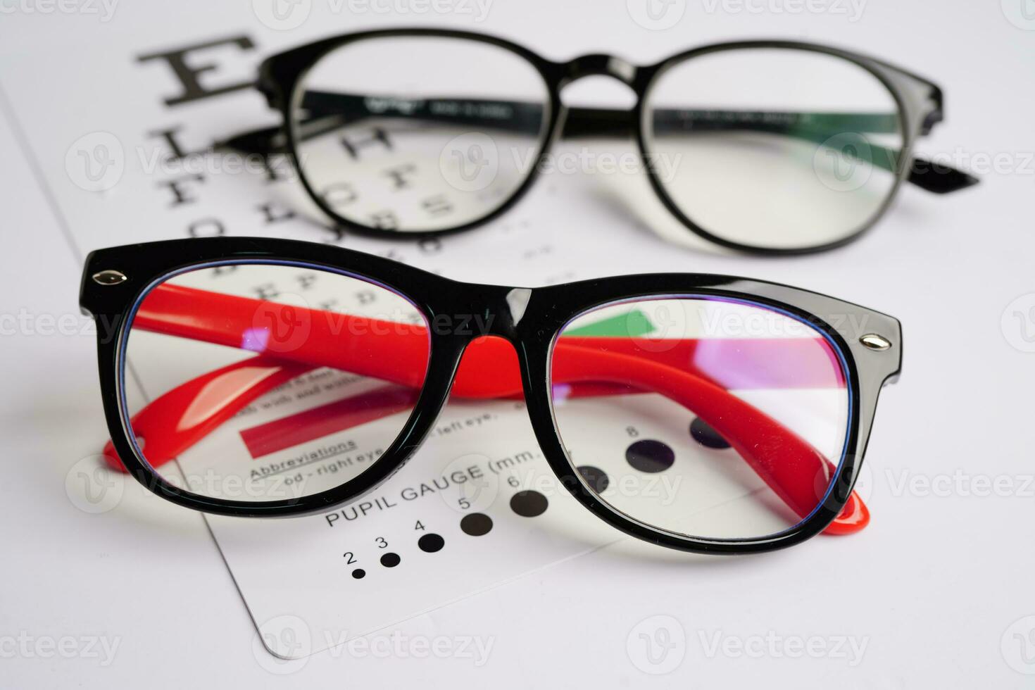 Glasses on eye exam chart to test eyesight accuracy of reading. photo