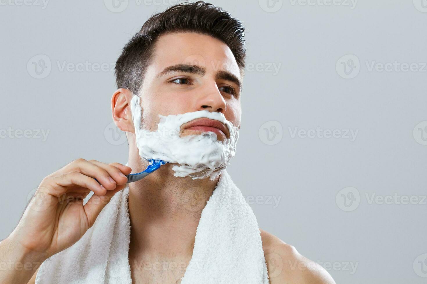 Handsome man shaving his beard photo