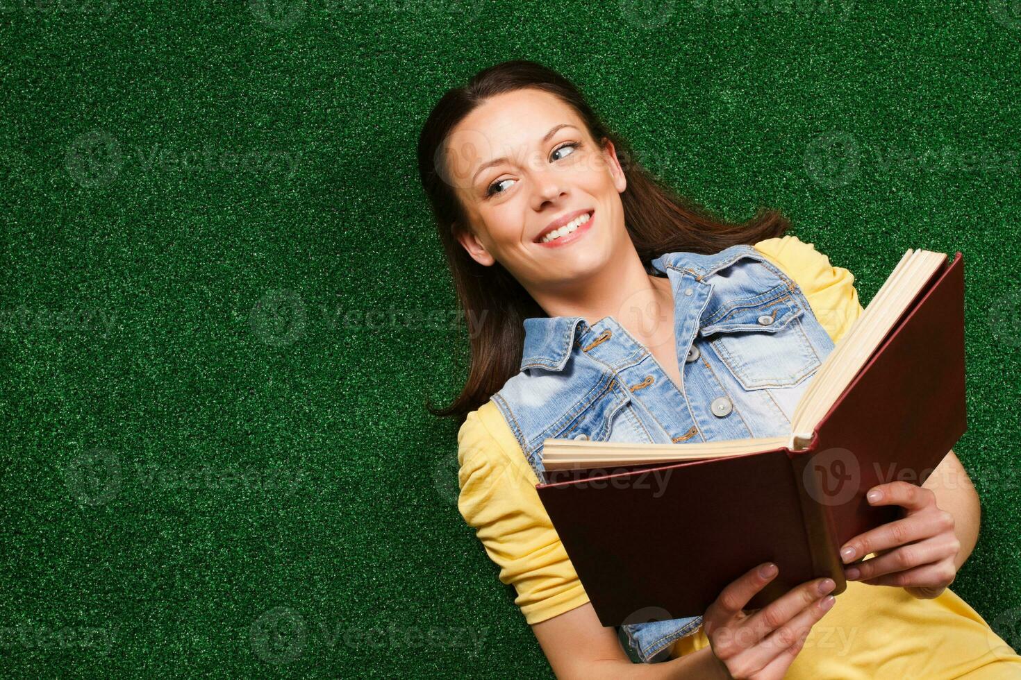 young-woman-is-lying-down-on-a-grass-and-reading-book-35270863-stock