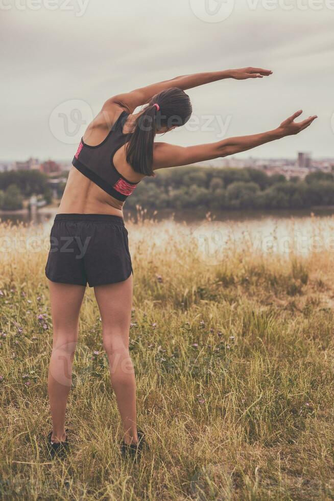 Woman stretching and exercising outdoor. photo