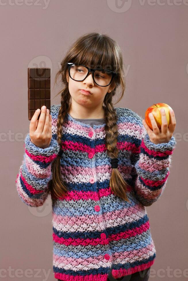 Little nerd girl wants eat chocolate rather then fruit photo