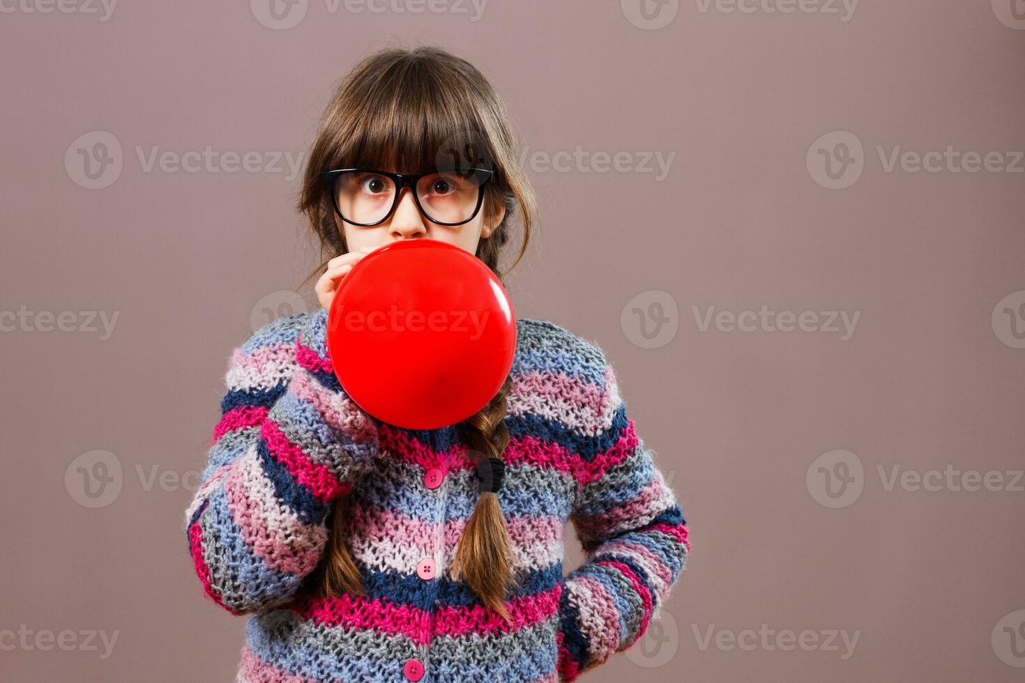 Little nerdy girl blowing balloon photo