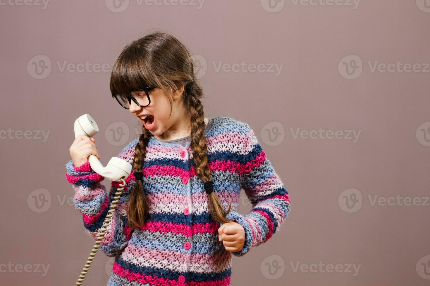 Little nerdy girl is shouting at the phone photo