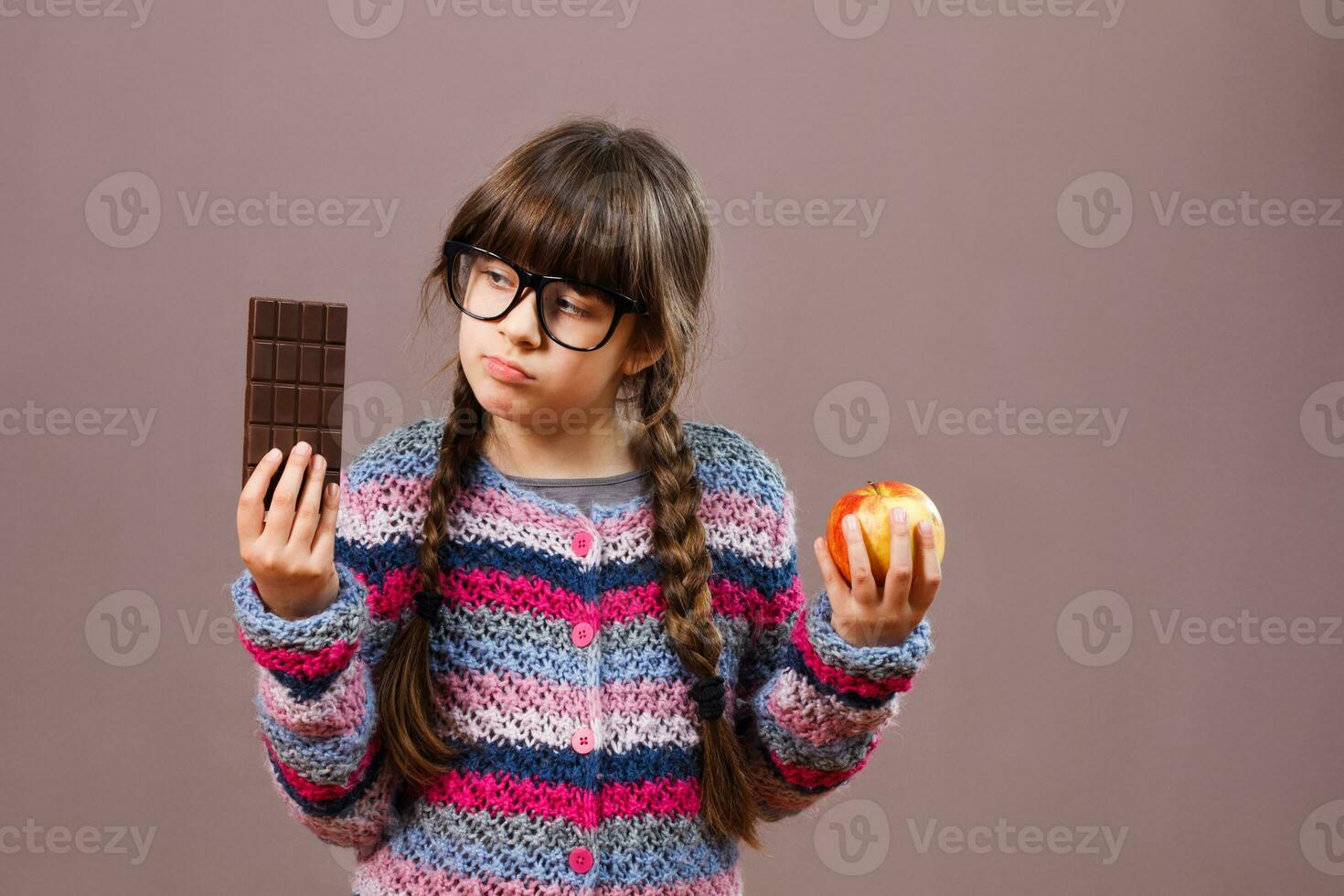 Little nerd girl wants eat chocolate rather then fruit photo