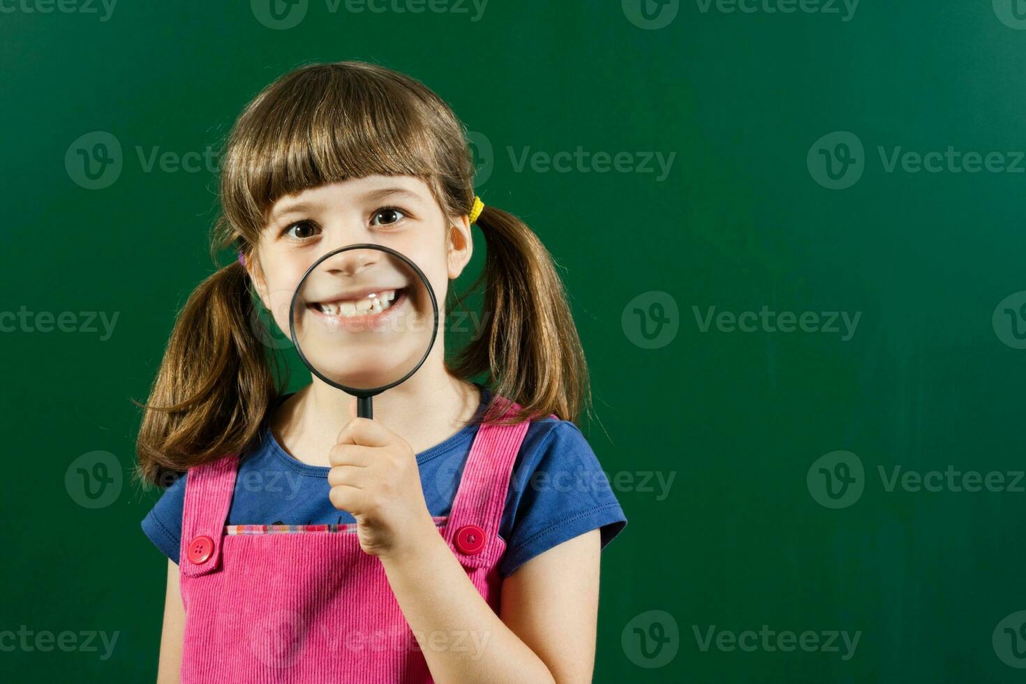 Schoolgirl with magnifying glass photo