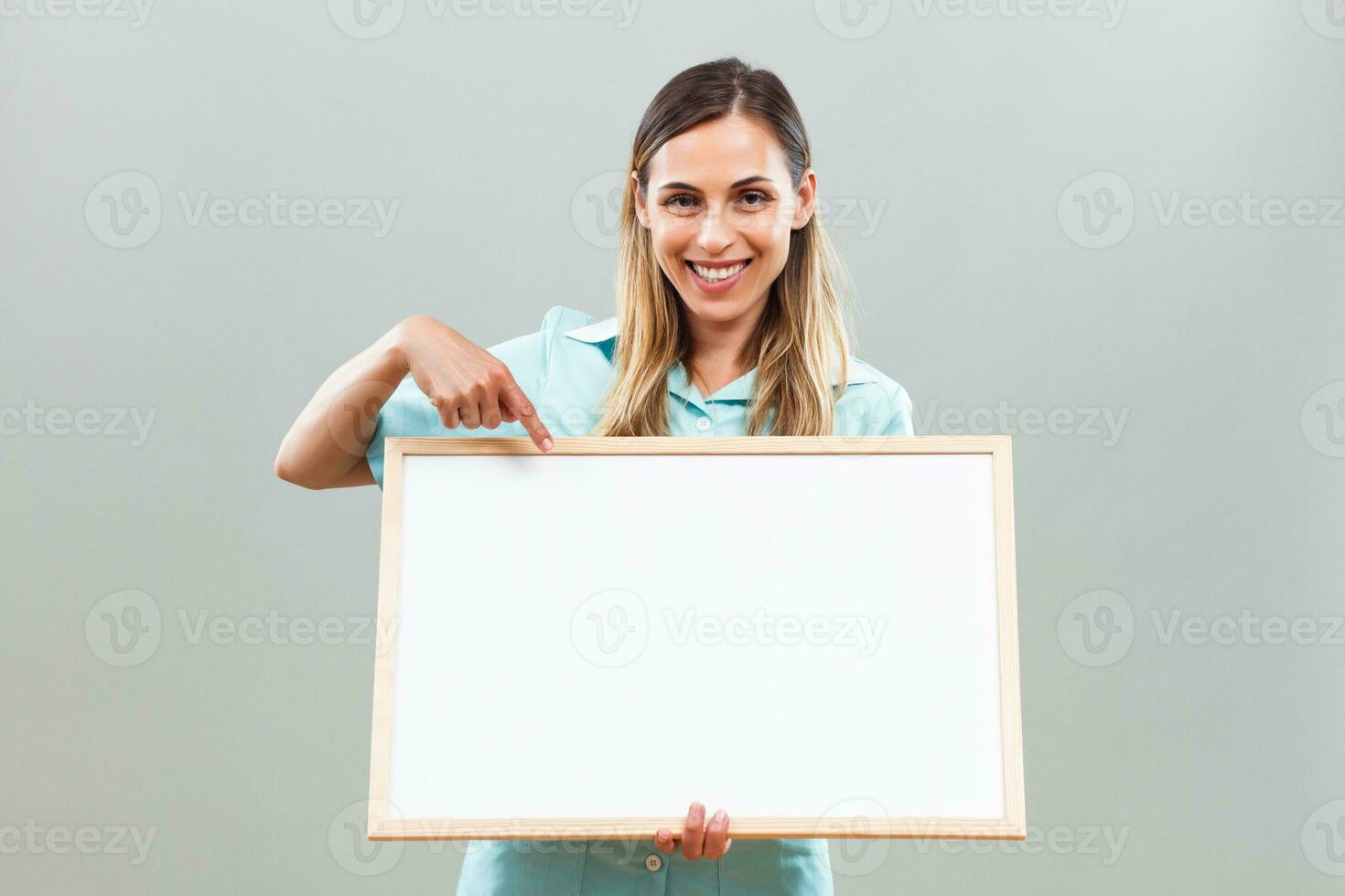 Beautiful nurse is pointing at whiteboard. photo