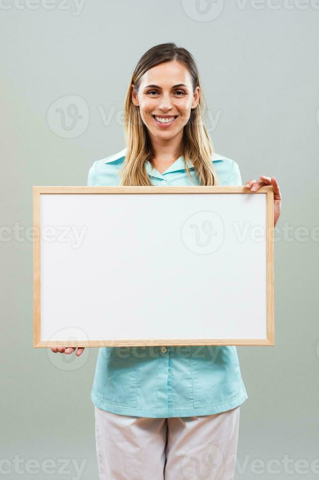 Beautiful nurse holding whiteboard. photo