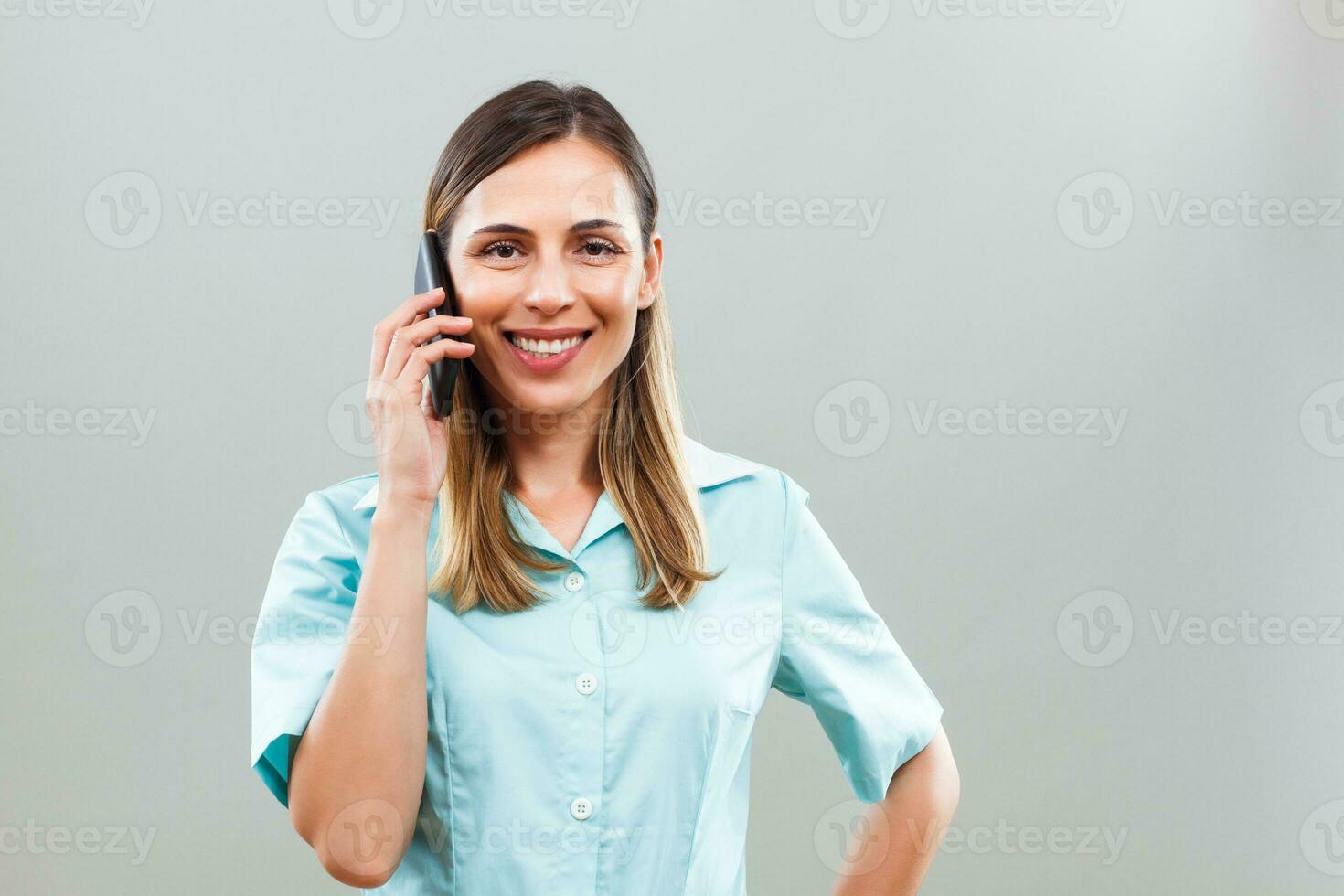 Beautiful nurse talking on mobile phone. photo