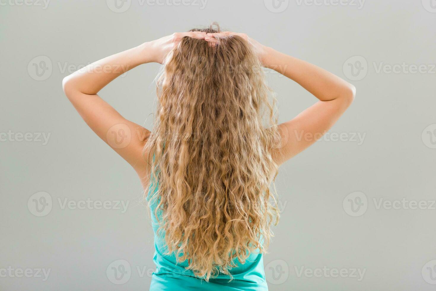 Woman with gorgeous long blonde hair on gray background. photo