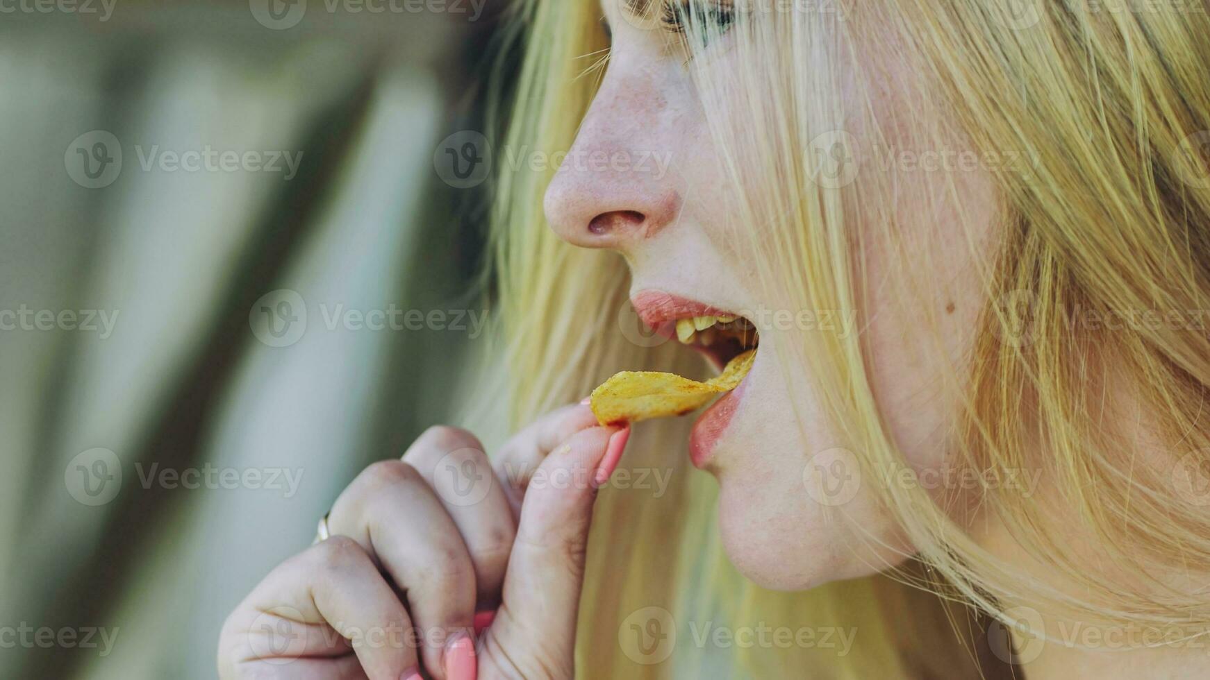 un niña comiendo papas fritas en un verano tarde. foto
