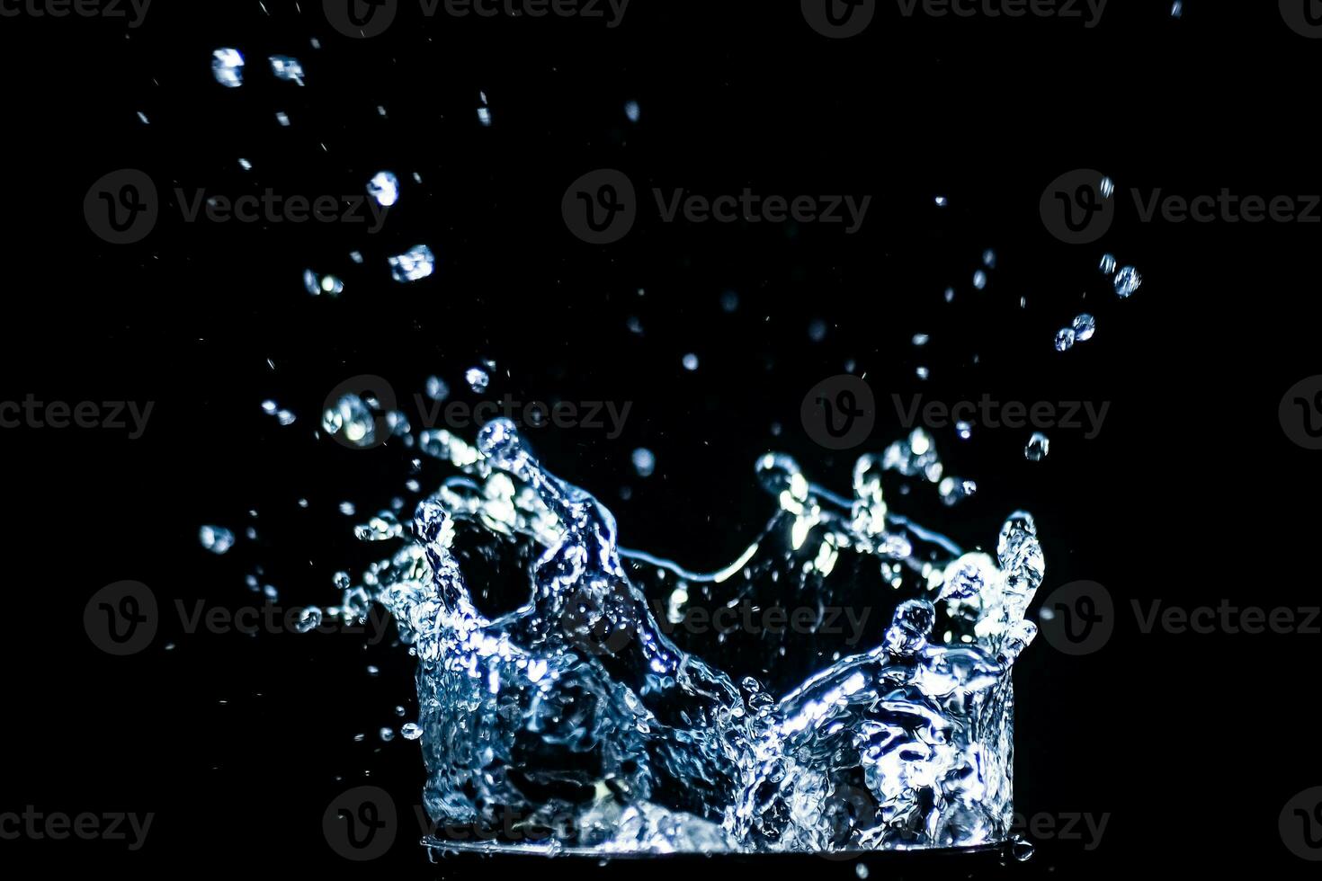 salpicaduras de agua sobre un fondo negro. gotas de agua esparcidas sobre un fondo negro foto