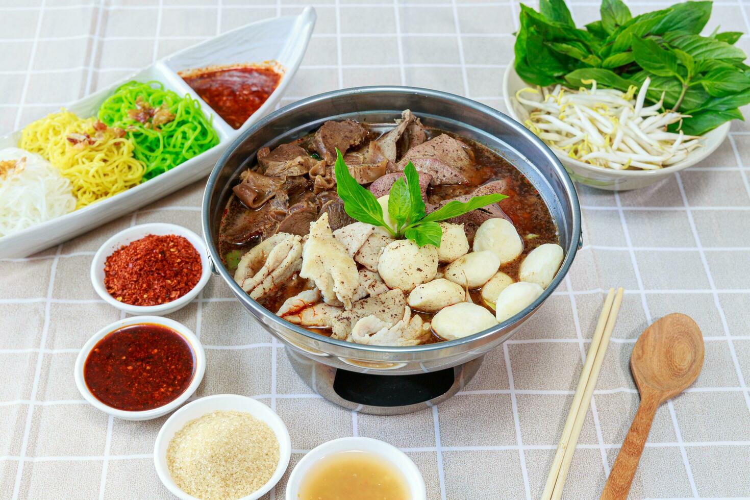 Braised Beef Soup in Hot Pot. One type of noodle dish that is popular in Thailand is called Boat Noodle Hot Pot. Served with different kinds of noodles such as rice vermicelli, thin noodles photo