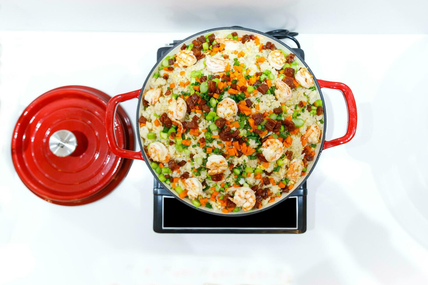 Stir fry rice with vegetables and shrimps in Red iron pan. Slate background. Top view. photo
