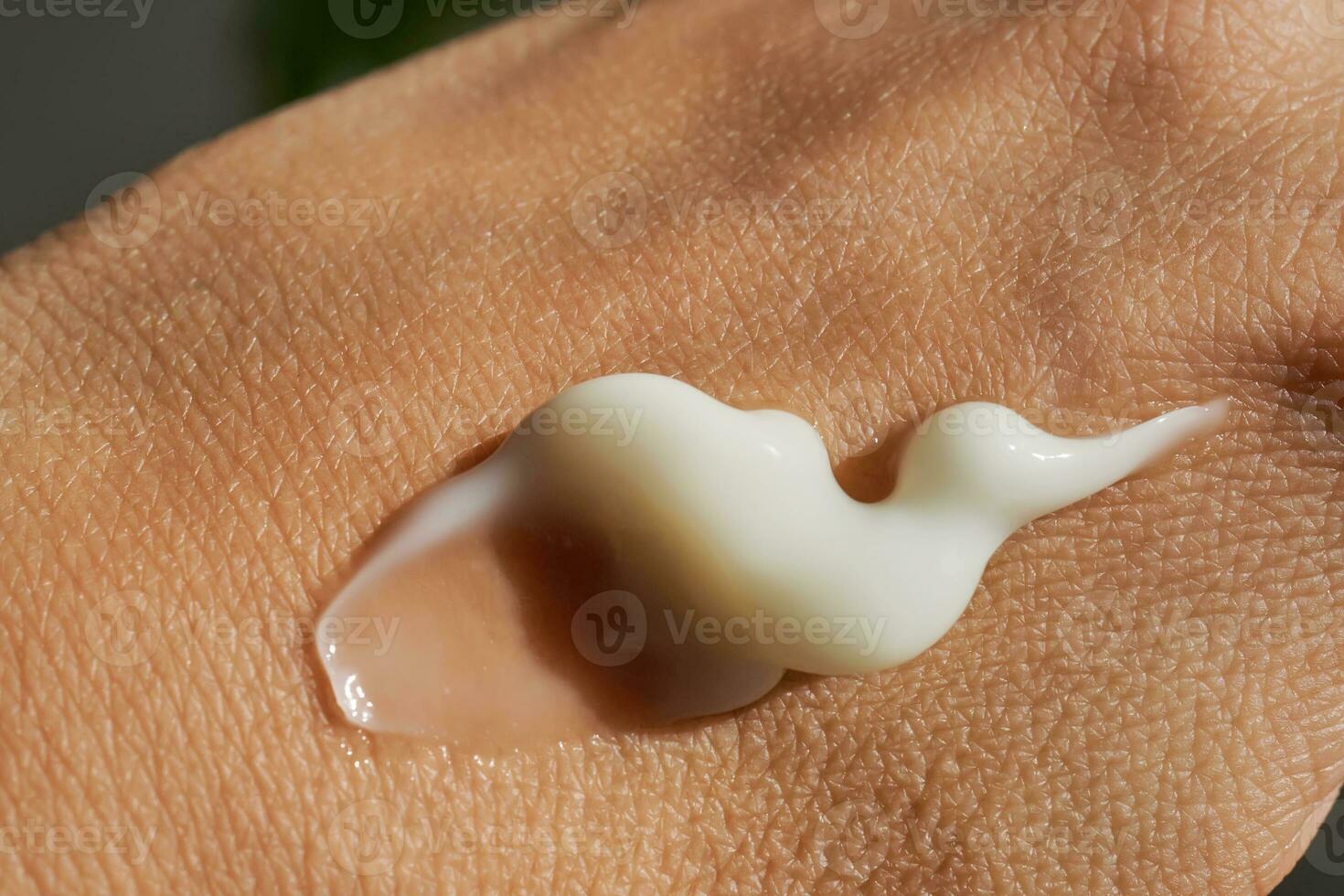 A smear of white moisturizer or sunscreen on a woman's hand. photo