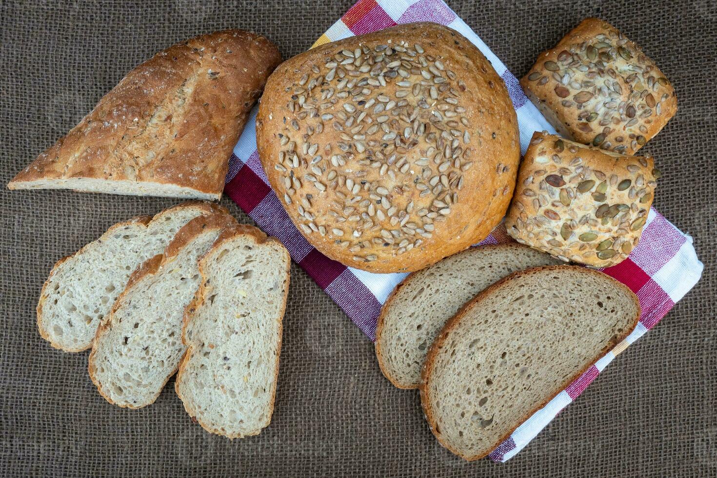 Fresh bread on table, top view. Baked dark bread and sliced bread. photo