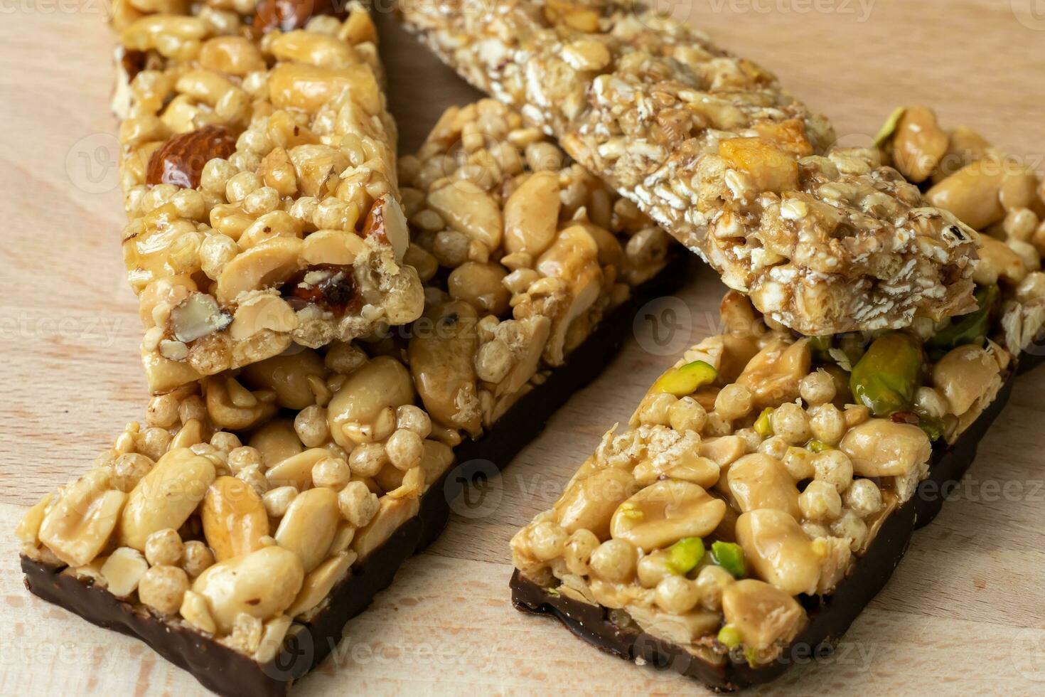 Cereal superfood energy bars with almond nuts, dry fruits, raisins chocolate on the wood table photo