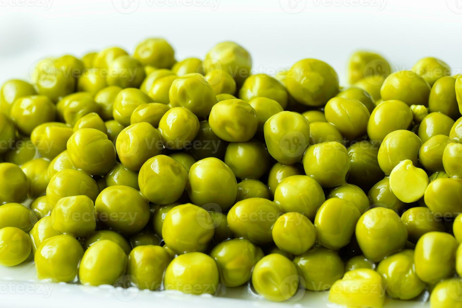 White bowl with canned green peas. Fermented food photo