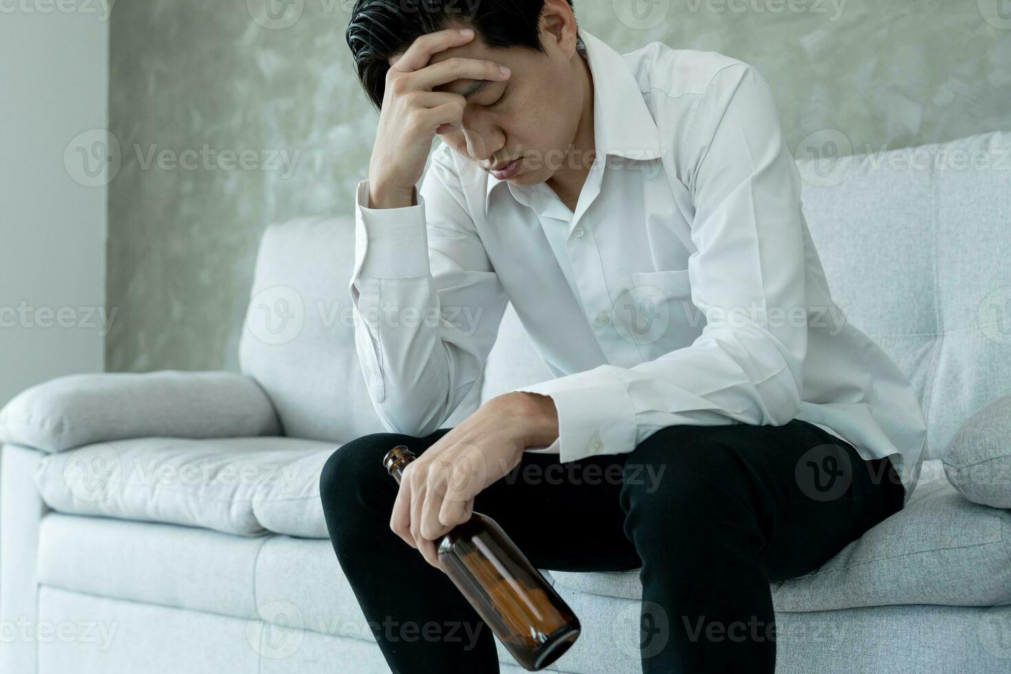 Depressed young business man addicted feeling bad drinking whiskey alone at home, stressed frustrated lonely drinking alcohol suffers from problematic liquor, alcoholism, life and family problems photo
