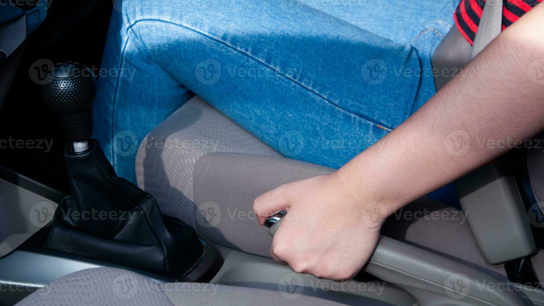 Woman driver's hand pulling the handbrake lever in the car. hand pulling on the handbrake lever in the car for parking safety and emergency, Safe driving and parking concept. photo