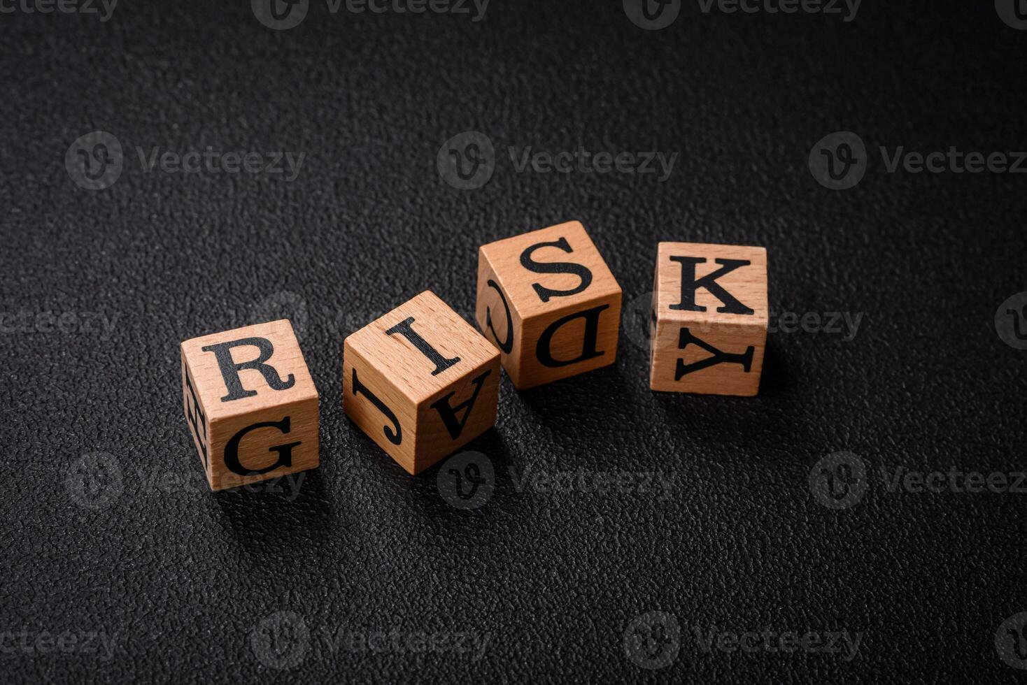 The inscription risk with wooden cubes on a dark concrete background photo