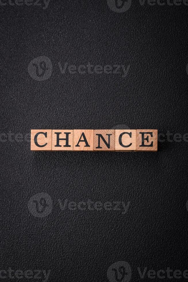 The inscription chance or change with wooden cubes on a dark concrete background photo