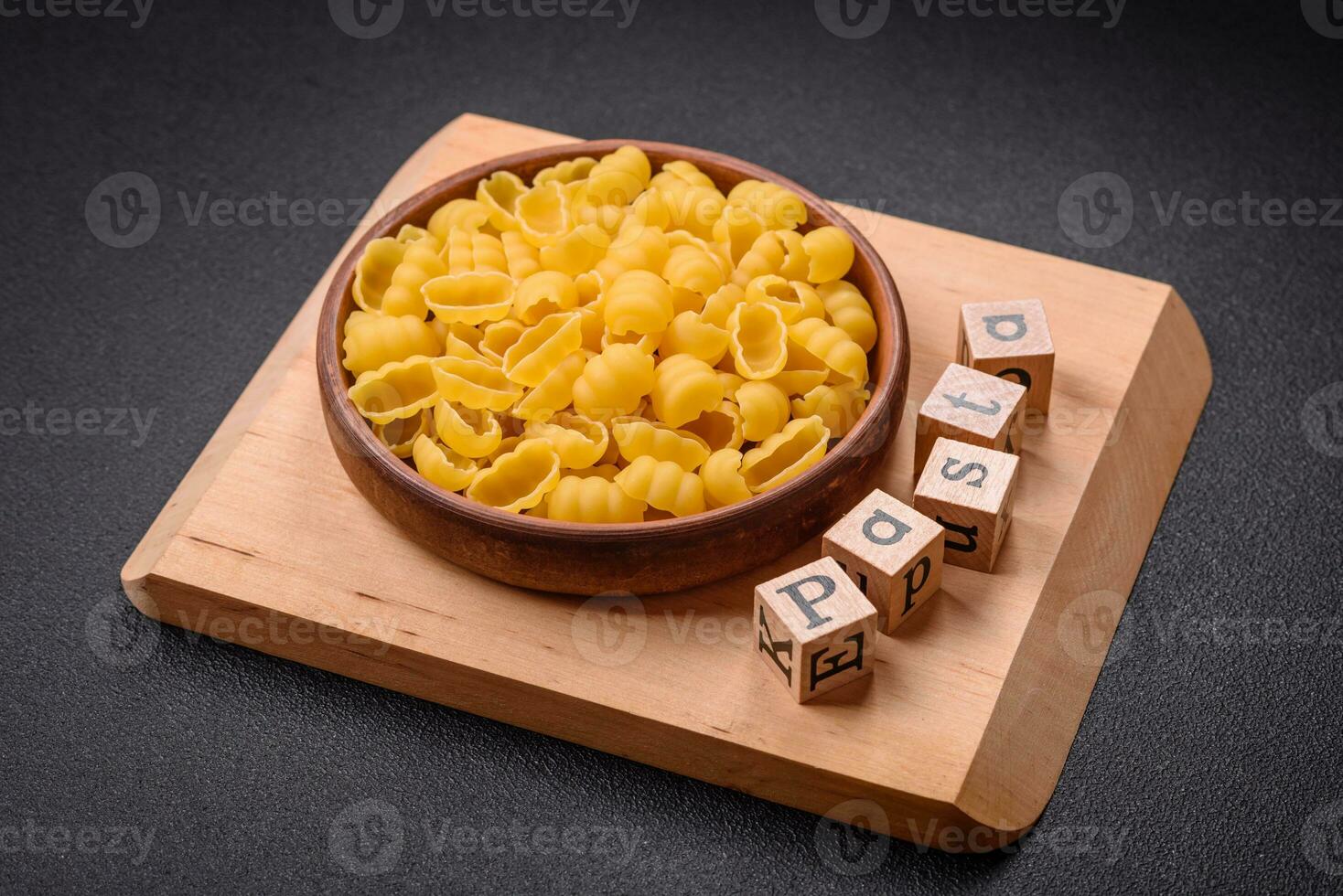 Raw durum wheat gnocchi pasta with salt and spices in a ceramic plate photo