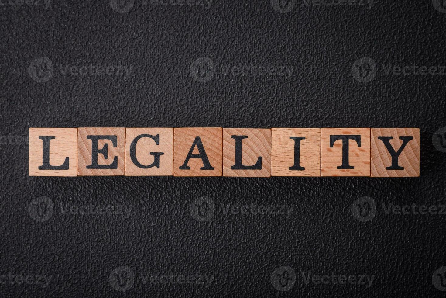 The inscription legality on wooden cubes on a dark concrete background photo