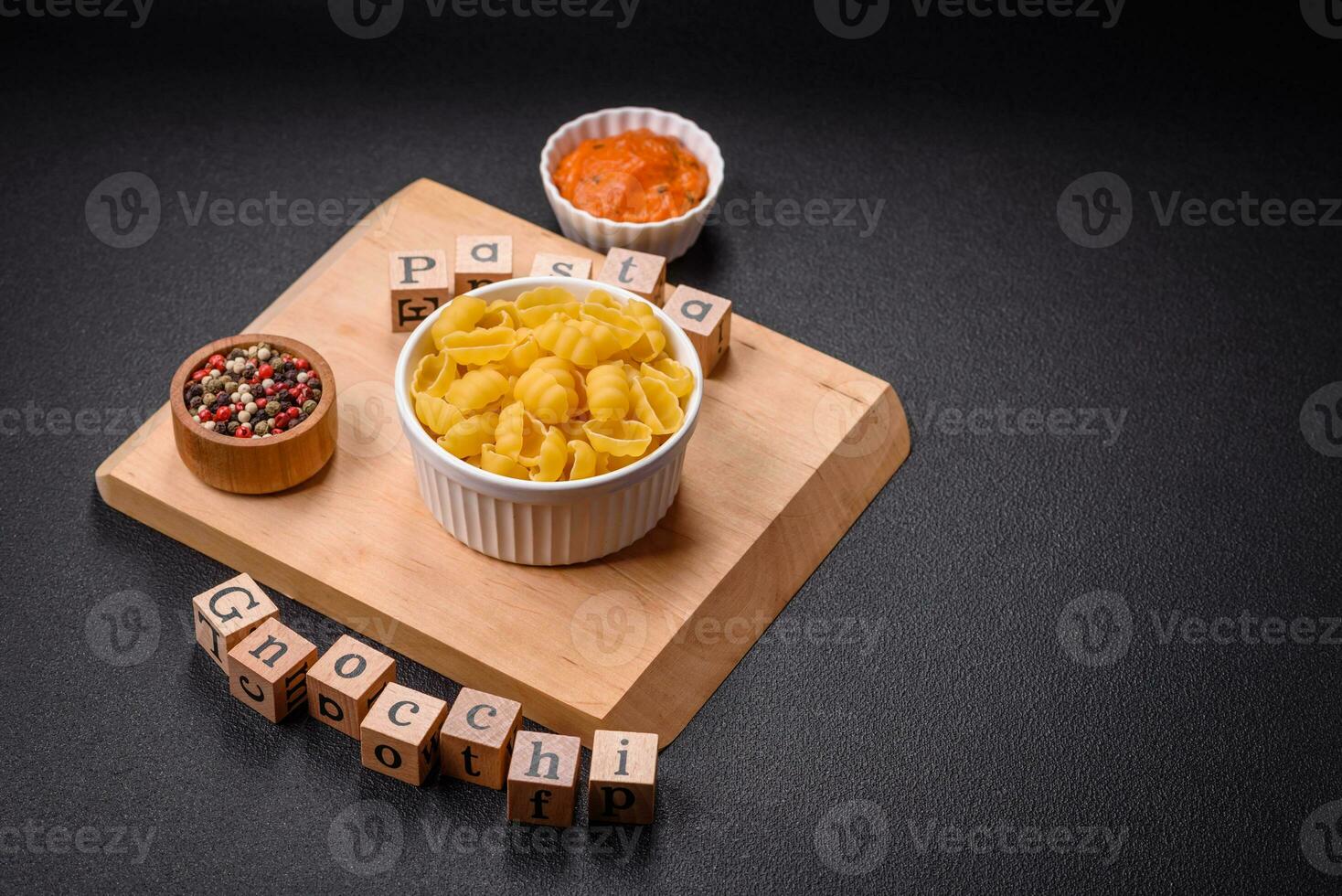 Raw durum wheat gnocchi pasta with salt and spices in a ceramic plate photo