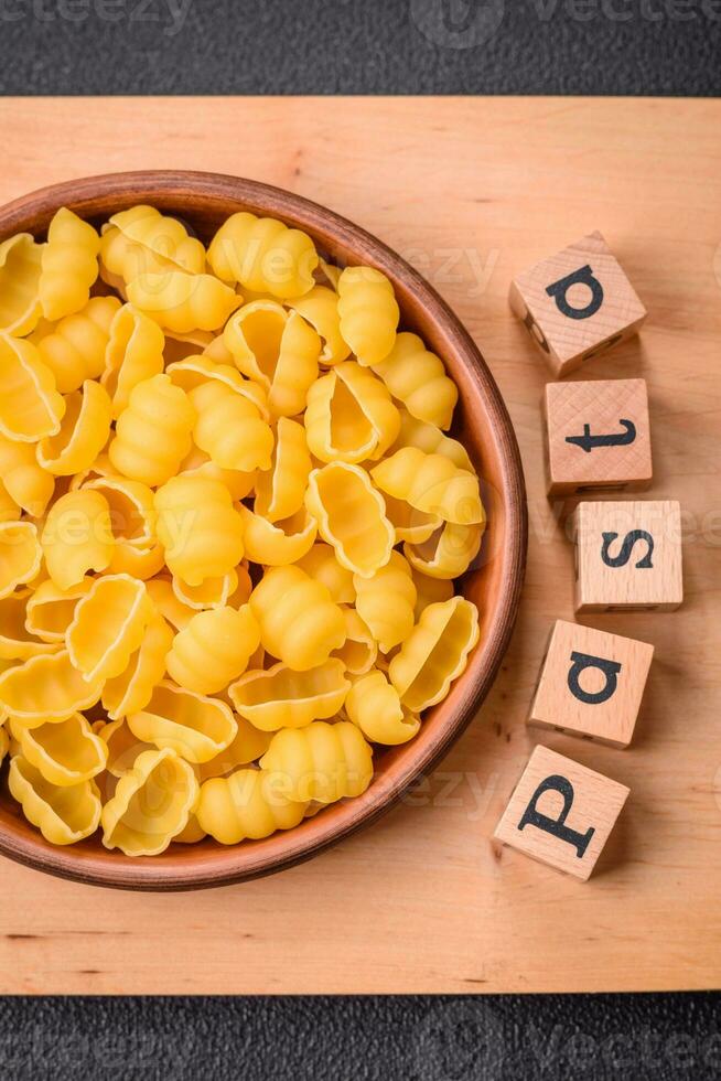 Raw durum wheat gnocchi pasta with salt and spices in a ceramic plate photo