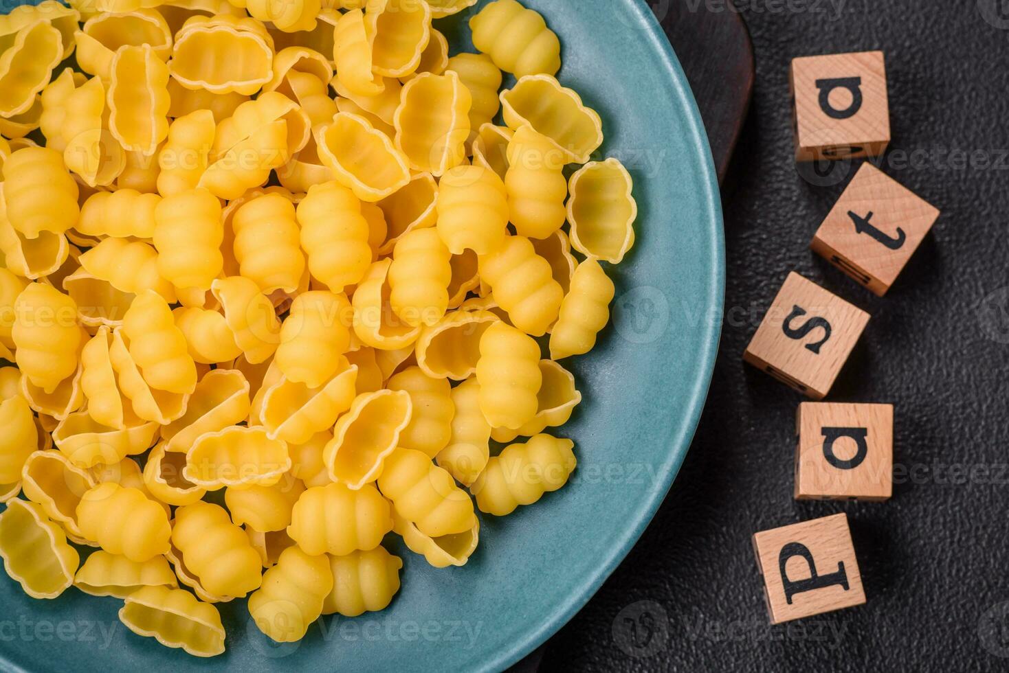 Raw durum wheat gnocchi pasta with salt and spices in a ceramic plate photo