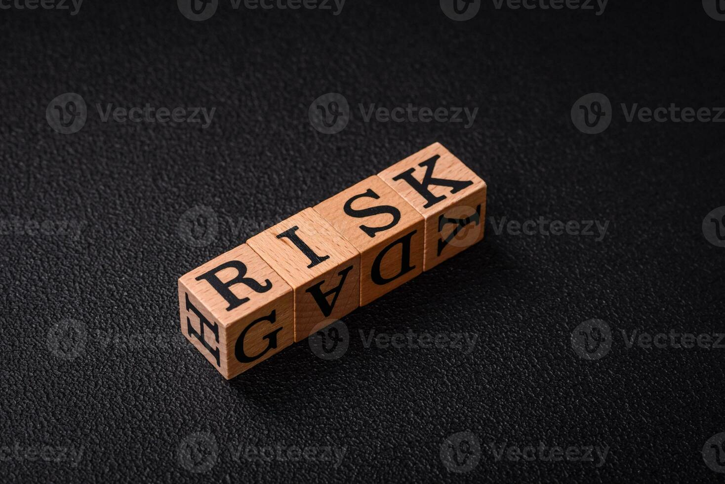 The inscription risk with wooden cubes on a dark concrete background photo