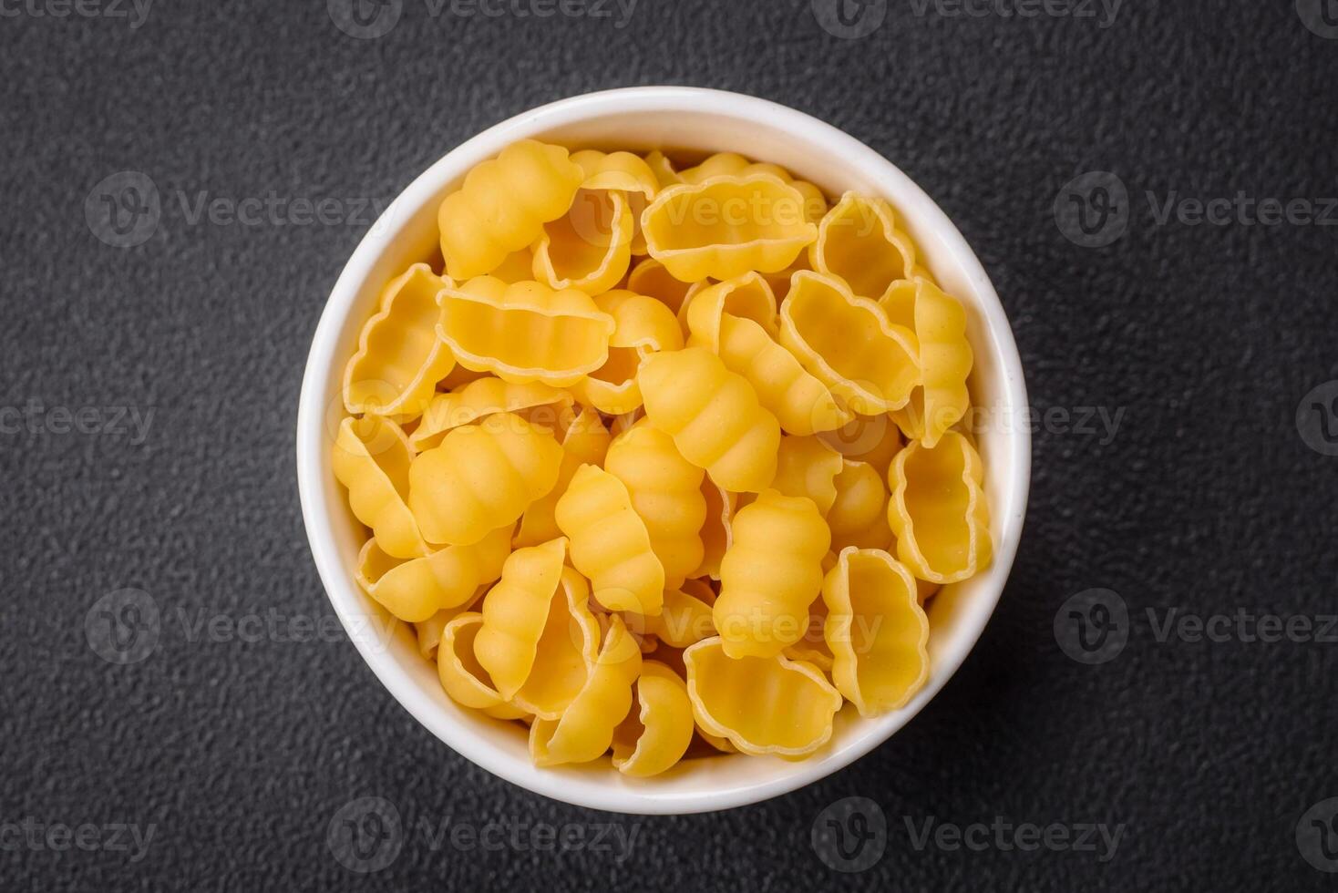 Raw durum wheat gnocchi pasta with salt and spices in a ceramic plate photo